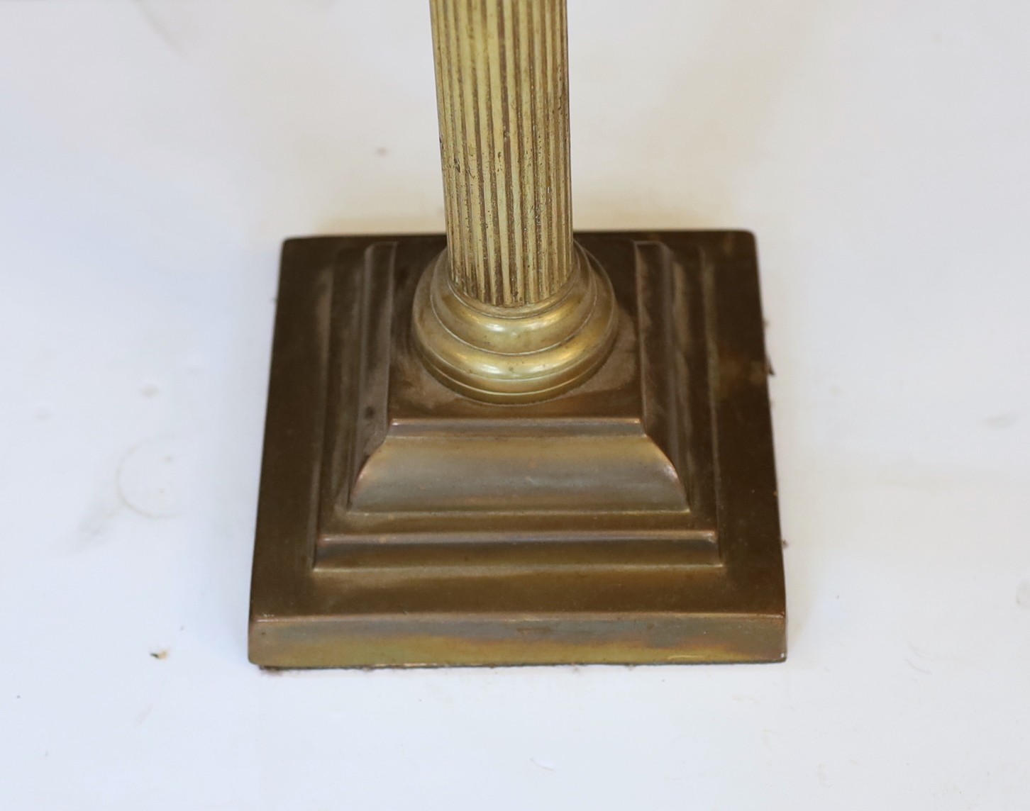 An Edwardian brass Corinthian column oil lamp with cut glass reservoir, improved duplex mechanism, etched globe and flue, height overall 85cm